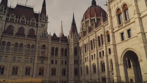 The Facade Of A Famous Parliament Building In Budapest Hungary Surrounded With Grass In The Ground U