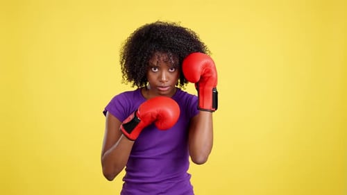 Woman Wearing Boxing Gloves Punching Toward Camera
