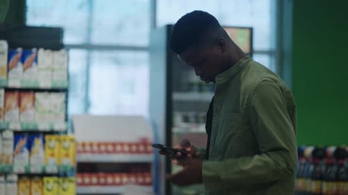 Black Man Shopping Healthy Food in Supermarket Background Female Buy Products Using Digital Gadget