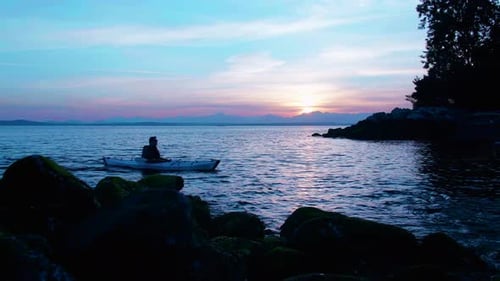 Man kayaking on a sea at sunset view