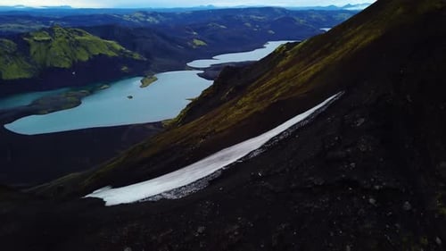 Aerial drone view of people hiking on a trail on a mountain ridge, on Iceland highlands