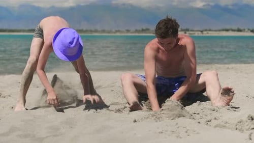 Father and Son Playing in the Sand on the Beach Family Travel and Vacation Concept Child with Dad