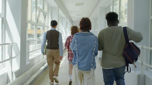Multi-ethnic College Students Walking Along Corridor