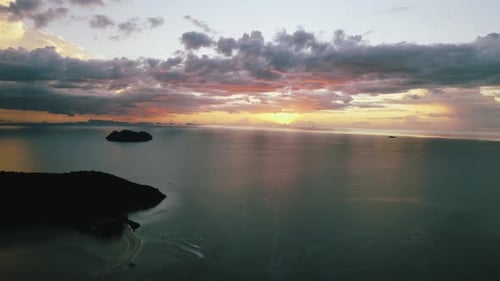 Cinematic sunset drone shot. Aerial view on tropical seascape with islands. Beautiful cloudy sky dur