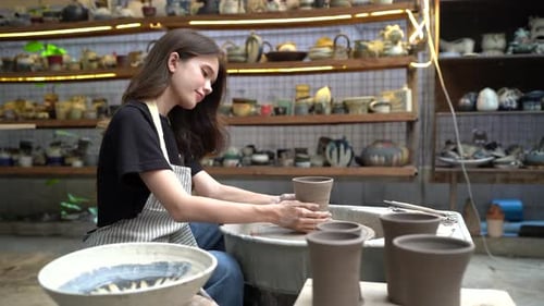 People Creating Pottery in Studio. Female artisan creating handmade ceramics in pottery workshop