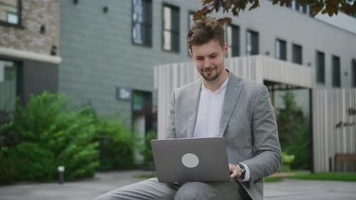 Happy Entrepreneur Working on Laptop Outdoors