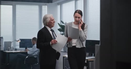 Female Financial Specialist Talks to Business Partner on Mobile Phone