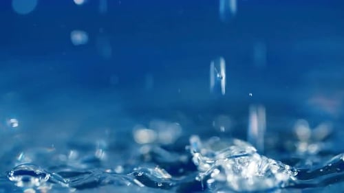 Water Droplets Forming Ripples on Blue Surface