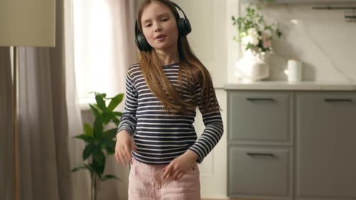 Happy Child Dances to Music With Headphones On