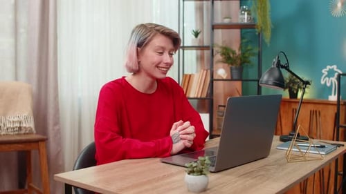 Smiling Woman Video Conferencing on Laptop at Home