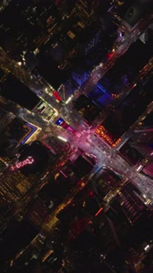 Vertical Views Capture Illuminated Traffic Streaming Through a Vibrant New York City Intersection in
