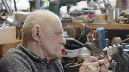 Senior Elderly Master Jeweler in Wheelchair Works in a Workshop