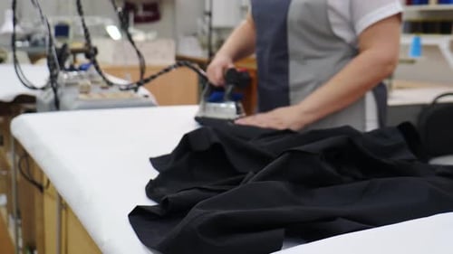 Female Worker of Garment Factory Ironing Products with Professional Iron with Hot Steam on Ironing