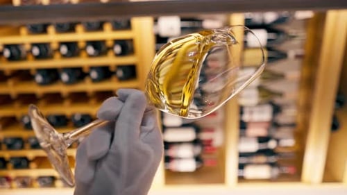 Vidéo verticale Gros plan d'un verre de vin tenu par un sommelier dans un restaurant italien