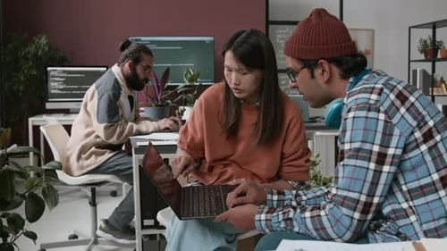 Diverse Product Manager and Website Designer Discussing Prototype on Laptop