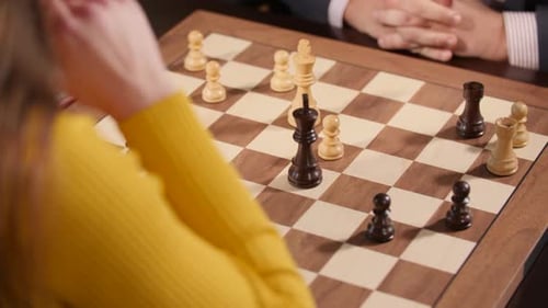 Schachspielerin bewegt ihren König auf einem Schachbrett und stoppt die Theke. Nahaufnahme
