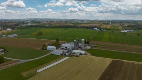Aerial time lapse of American farm on bright spring day. Drone hyperlapse as clouds move over USA ru