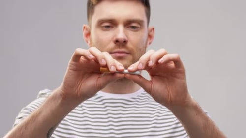 Quit Smoking and People Concept - Young Man in Striped T-Shirt Braking