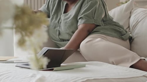 Woman Reviews Documents on Couch at Home