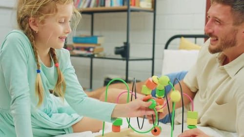 Father and Daughter Play Together with Colorful Toy