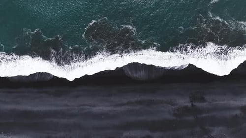 Aerial View of Iceland's Black Sand Beach with Ocean Waves