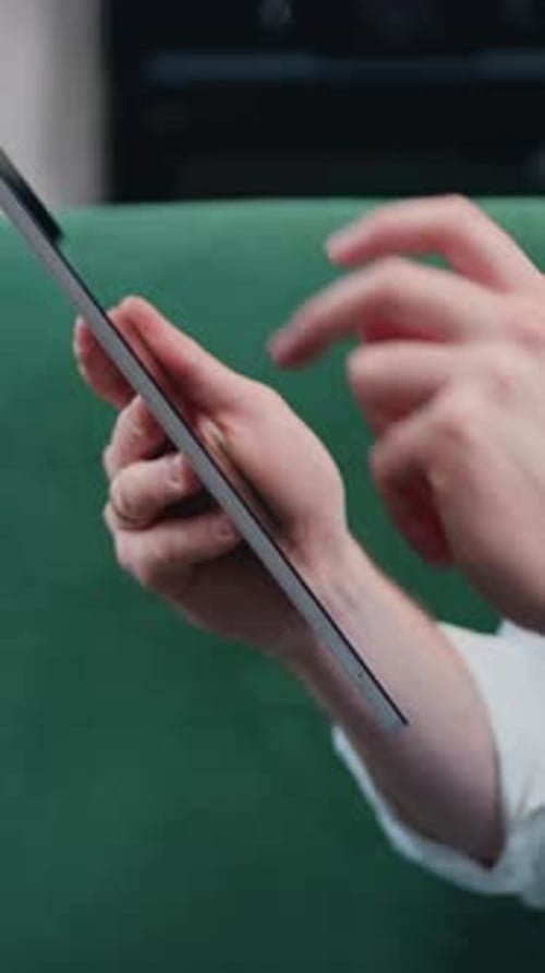 Homme touchant l'écran d'une tablette numérique, mains d'un homme d'affaires en gros plan assis sur un canapé, travail à distance