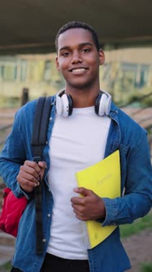 Portrait individuel vertical d'un jeune étudiant afro-américain portant un sac à dos et une note