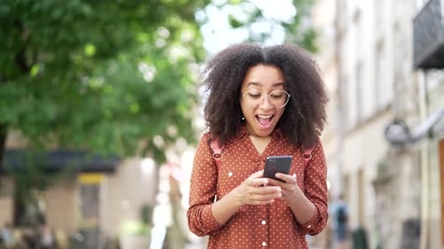 Happy Woman Expressing Joy While Looking at Phone