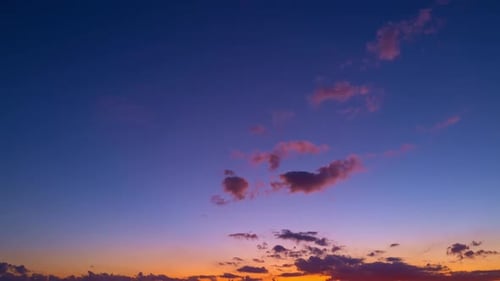 Sonnenuntergang mit Sonne und Wolken auf blauem und orangefarbenem Himmel mit Sonnenstrahlen, Nachthimmel, Zeitraffer, Bewegung