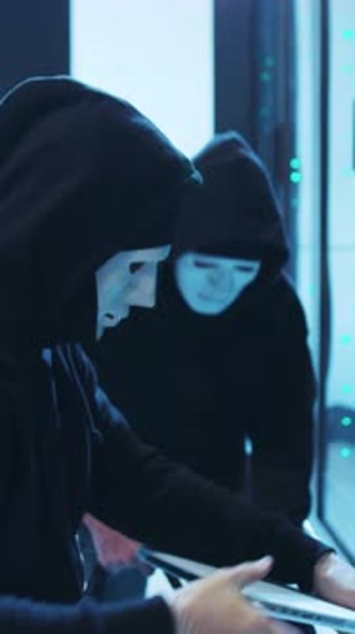 Figures in Masks Hacking in a Server Room