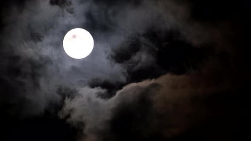 Eerie Moon Shining Through Dark Stormy Night Clouds