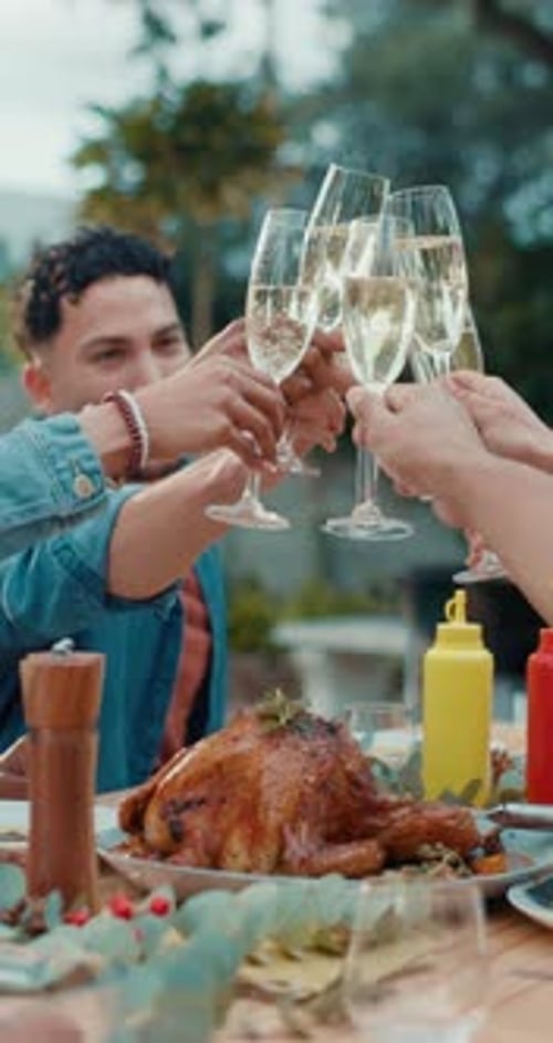 People Clinking Champagne Glasses at Outdoor Thanksgiving Table