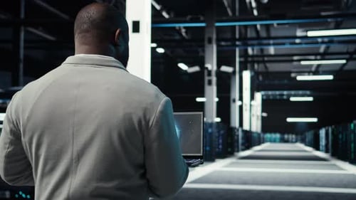 Server Room Admin Using Laptop to Do Infrastructure AI Automatization