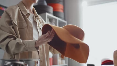 Woman Shaping and Steaming a Stylish Wide-Brimmed Hat