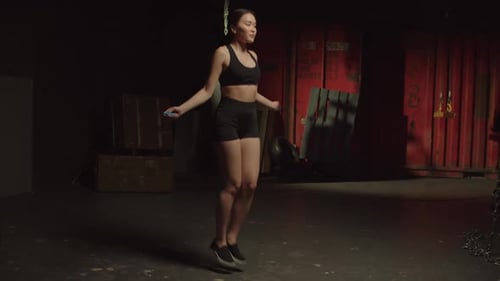 Pretty Active Sporty Fit Asian Woman Doing Jump Rope Cardio Workout at Gym