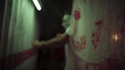 Masked Man with Chainsaw in Urban Alley