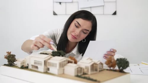 Closeup of beautiful architect measure the architectural model. Immaculate.