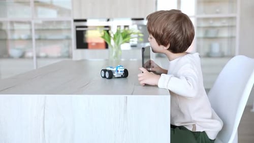 Young Boy Using Smartphone at Kitchen Counter