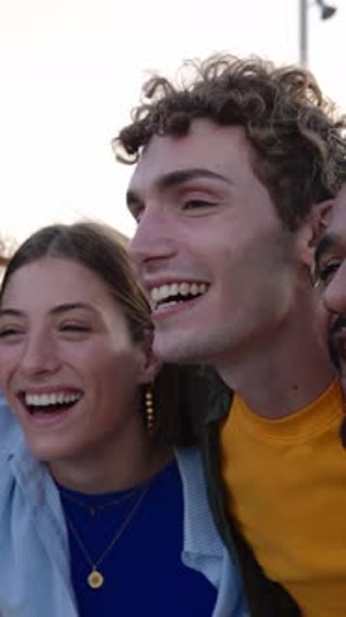 Grupo feliz de jovens se abraçando rindo ao ar livre
