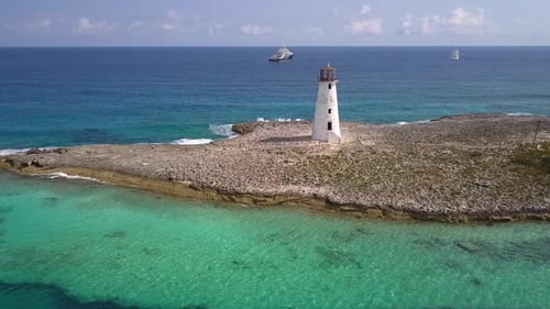 Aerial view away from the Nassau Harbour Lighthouse, in sunny Bahama, USA - pull back, drone shot