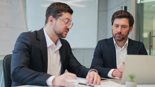 Businessmen Working Together on a Laptop and Shaking Hands