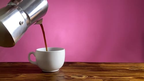 Verter café moka fuerte en una taza blanca sobre madera