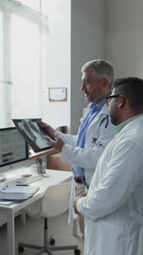 Doctors Reviewing X-Ray Image in Bright Office