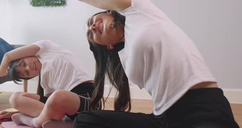 Mother and Daughter Stretching Together at Home
