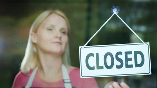 Cute Woman Steals a Sign Open on the Door of the Store