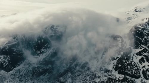 Vue aérienne des sommets des montagnes enveloppés d'un épais brouillard et de nuages en hiver dans les Lofoten, en Norvège.
