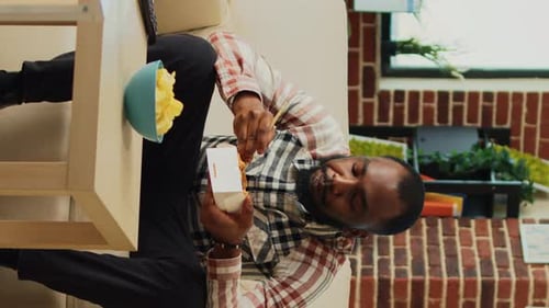 Bearded Man Enjoys Noodles and Beer at Home