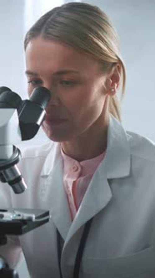 Close Up Face Scientist Woman Looking Under the Microscope at Sunlight in the Laboratory Medicine