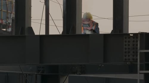 Construction Worker Welding Steel Beam on Site