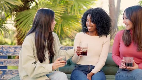 Multiethnic Friends Smiling and Drinking in the Garden